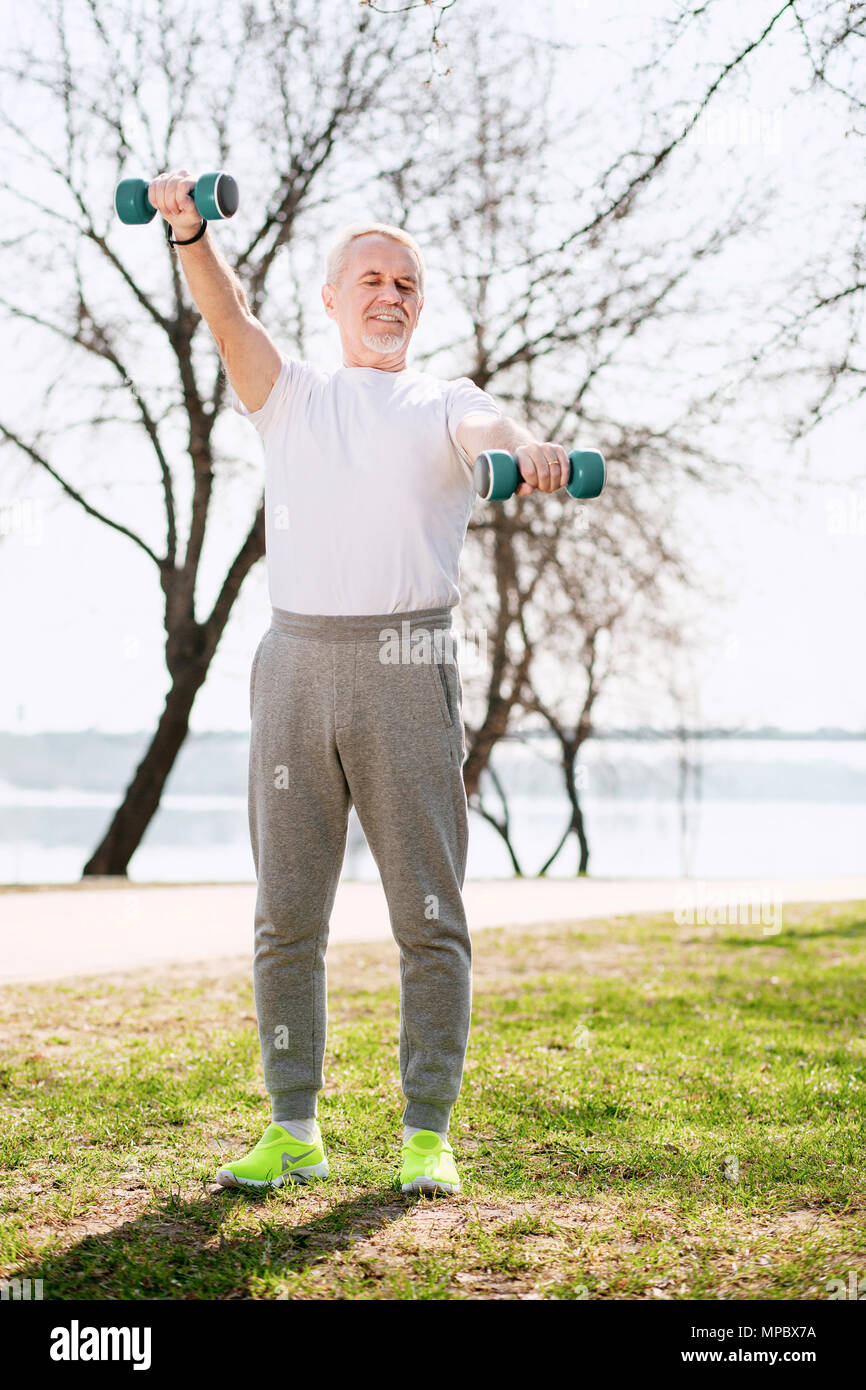 Focalizzato uomo maturo rafforzare muscoli Foto Stock