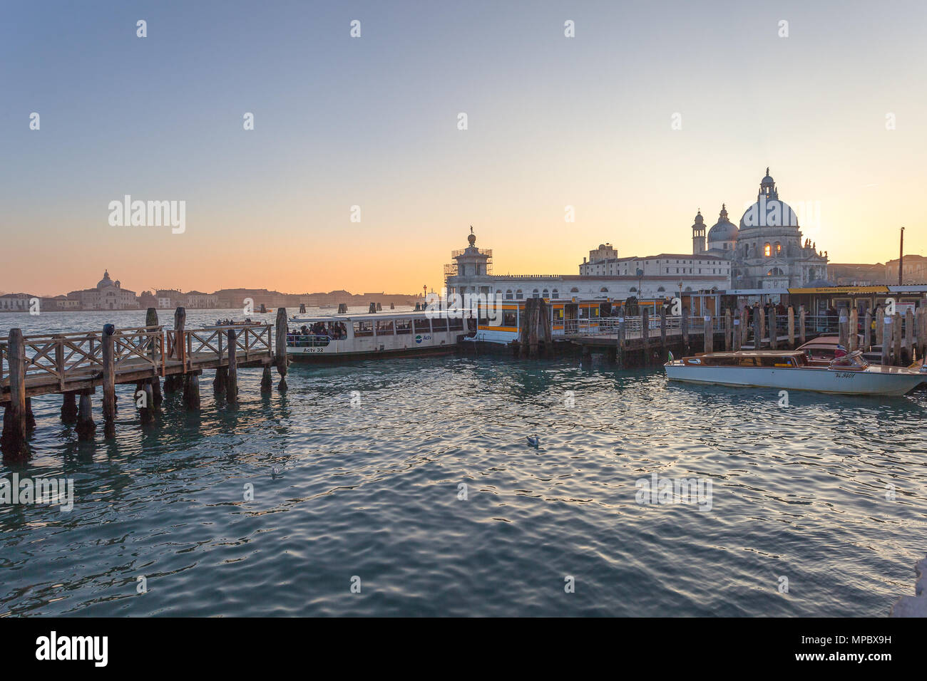 Venezia, Italia - 02 gennaio 2018: vaporetto il terminale al tramonto davanti alla Basilica della Salute. Il vaporetto è il mezzo pubblico per eccellenza di Foto Stock