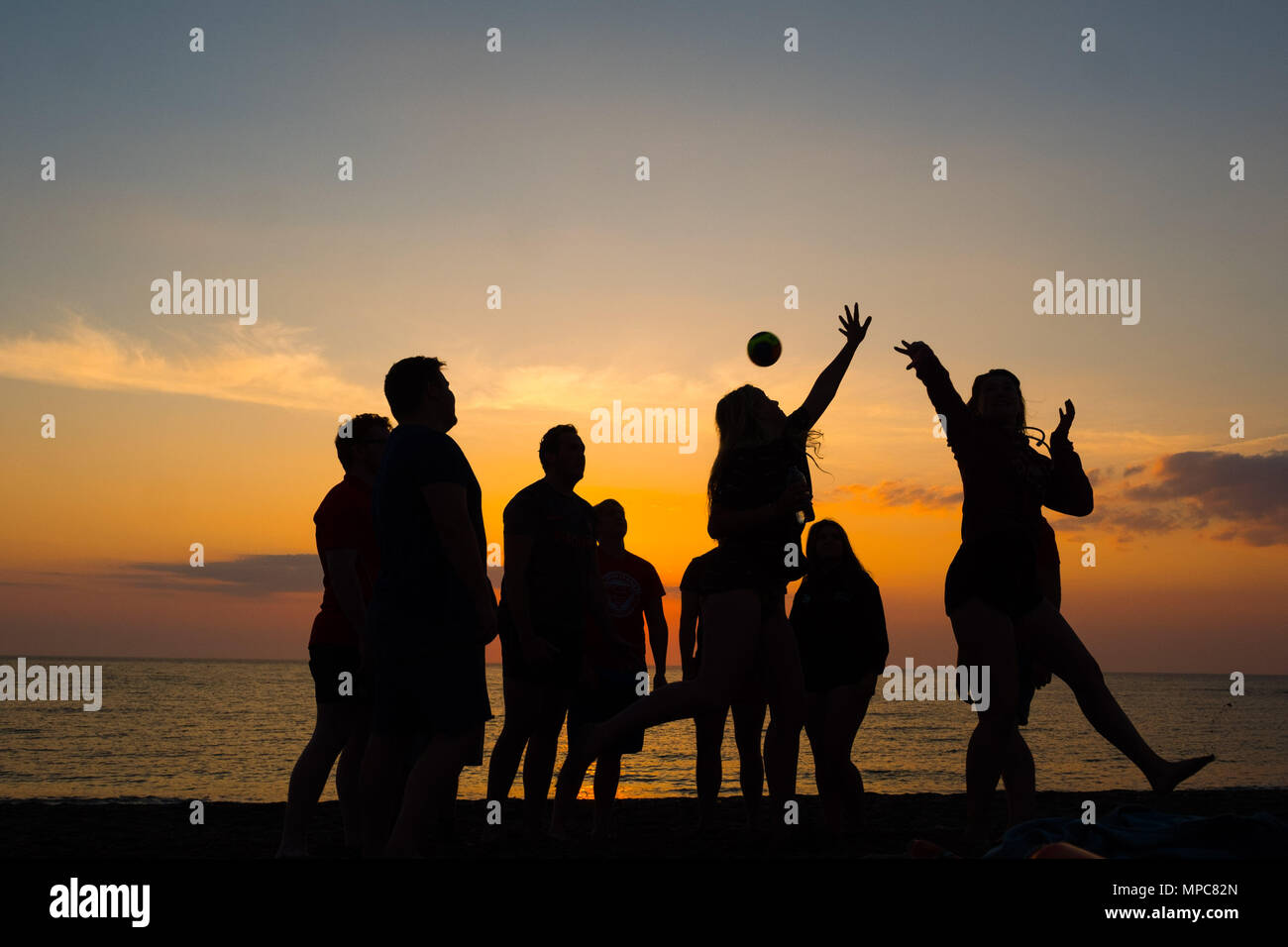 Aberystwyth Wales UK, martedì 22 maggio 2018 UK Meteo: un gruppo di studenti universitari la riproduzione di giochi con la palla sulla spiaggia si stagliano contro il sole di setting in Aberystwyth, alla fine di una giornata di caldo sole primaverile foto © Keith Morris / Alamy Live News Foto Stock