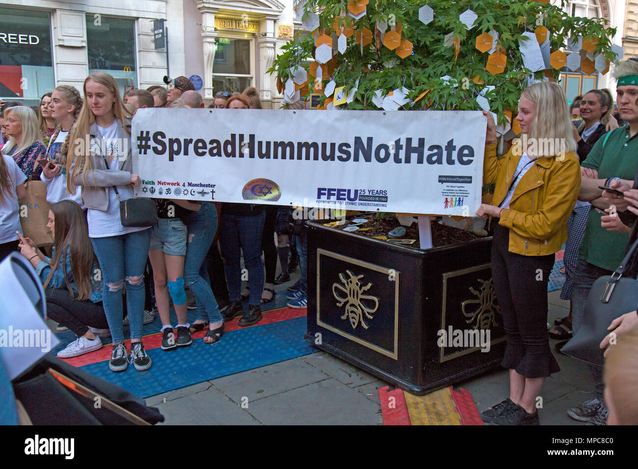 Manchester, Regno Unito. 22 Maggio, 2018. Due giovani femmine con un banner dicendo 'spread Hummus Non odio', in St. Ann's Square nel centro di Manchester, a ricordare il 22 vittime dei bombardamenti contro il Manchester Arena, dopo il concerto dato dalla cantante americana Ariana Grande. Credito: Rob Carter/Alamy Live News Foto Stock