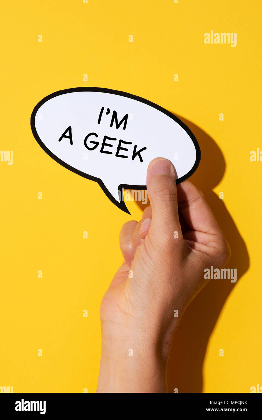 Primo piano della mano di un giovane uomo caucasico con un discorso balloon con il testo io sono un geek scritto in esso, su uno sfondo giallo Foto Stock