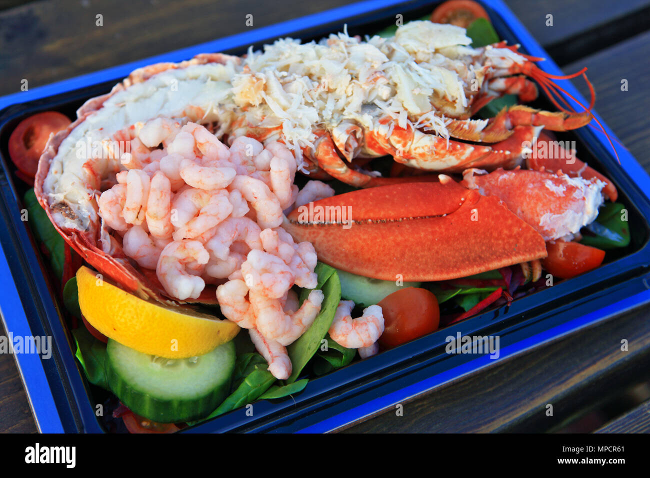 Piatto di frutti di mare costituito da una mezza aragoste, gamberi e chele di granchio con insalata Foto Stock