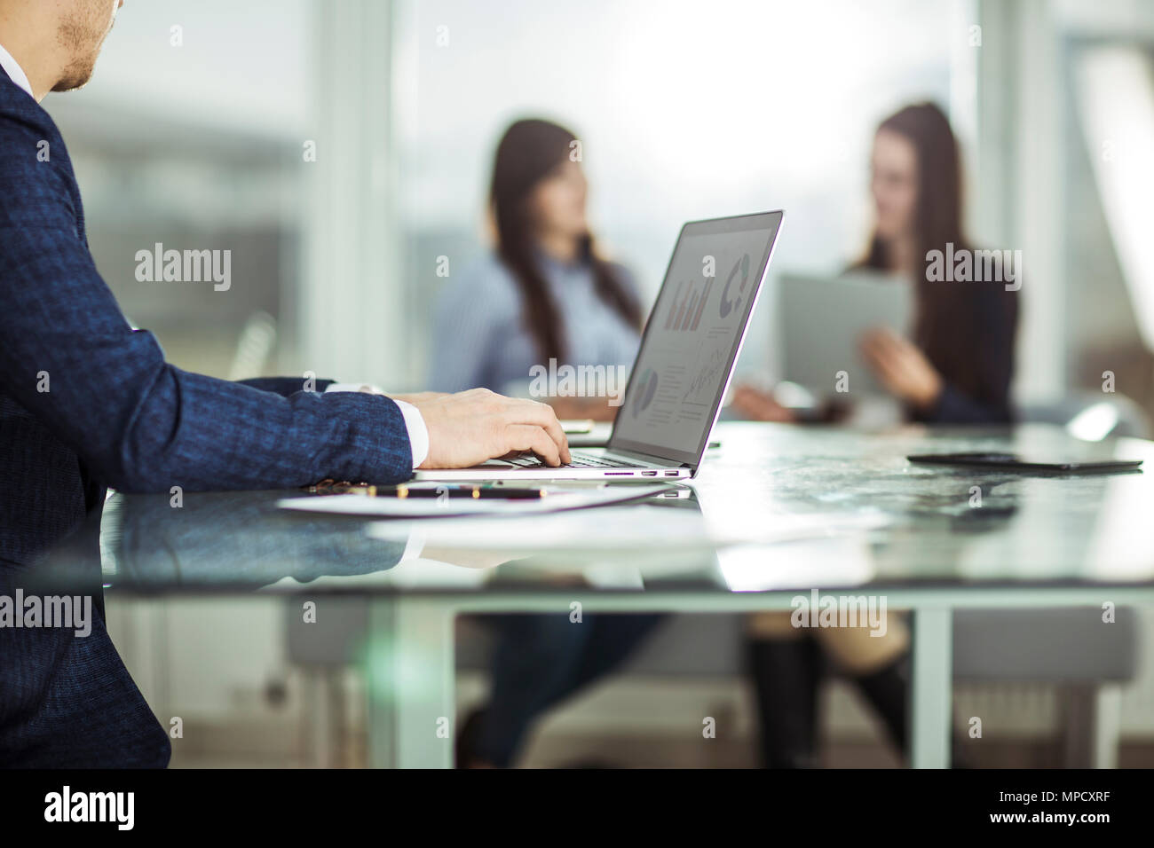 I responsabili finanziari lavorando sul computer portatile con i dati finanziari sul posto di lavoro in un ufficio moderno Foto Stock