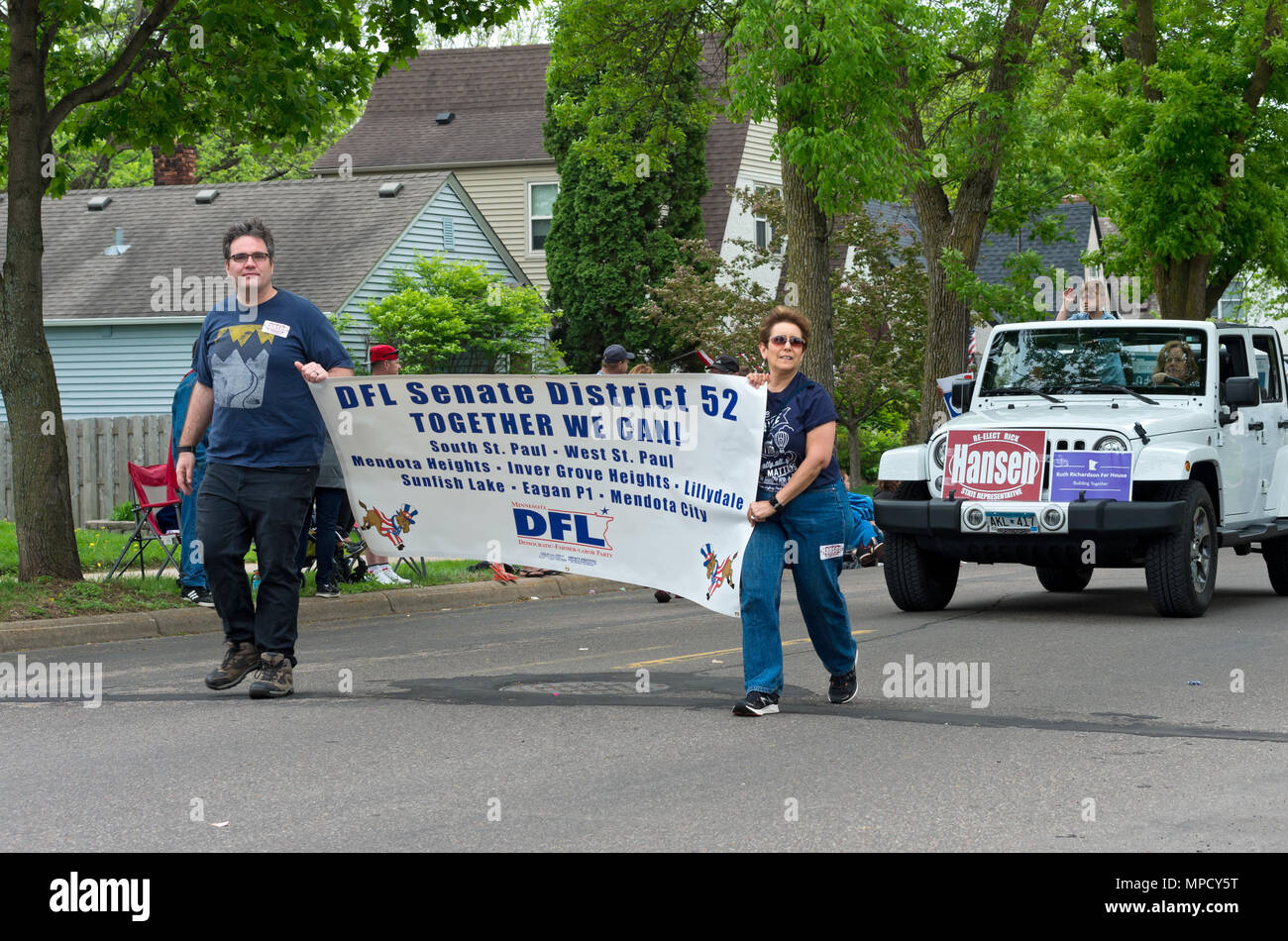 A ovest di Saint Paul, Minnesota, Stati Uniti d'America - 19 Maggio 2018: i membri della locale Democratic-Farmer-Partito Laburista unità organizzatore tenere premuto segno e marzo in parata. Foto Stock