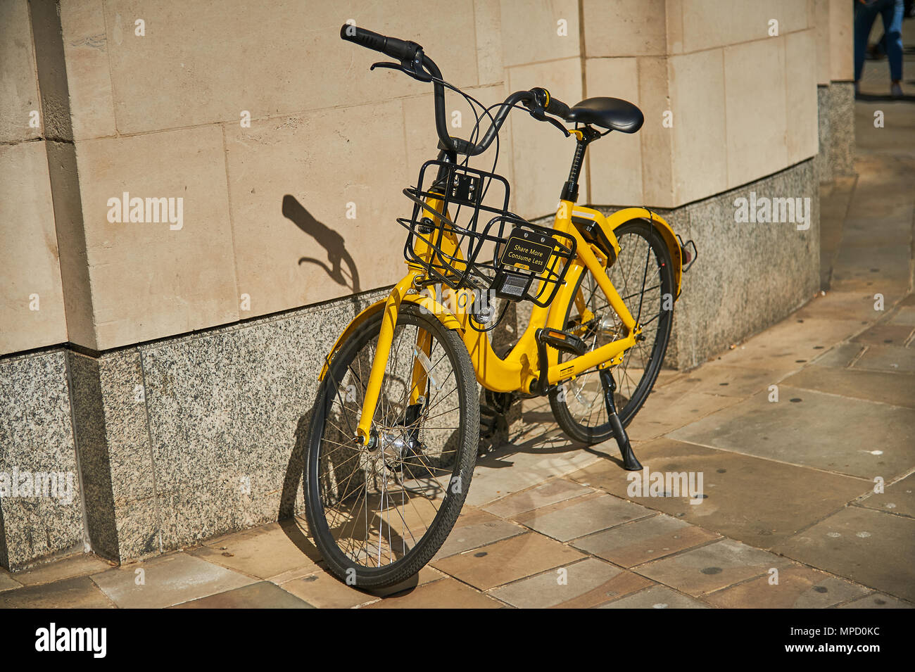 Giallo dockless nolo bici lasciate al di fuori di un edificio in un ambiente cittadino Foto Stock