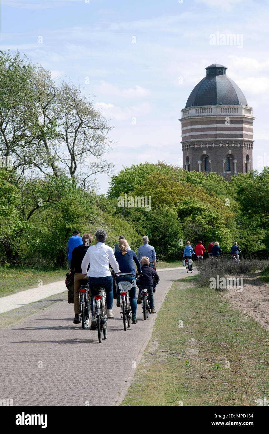 Scheveningen, Paesi Bassi-maggio 14, 2015: persone escursioni in bicicletta nelle dune di Scheveningen con la torre dell'acqua in background. Foto Stock