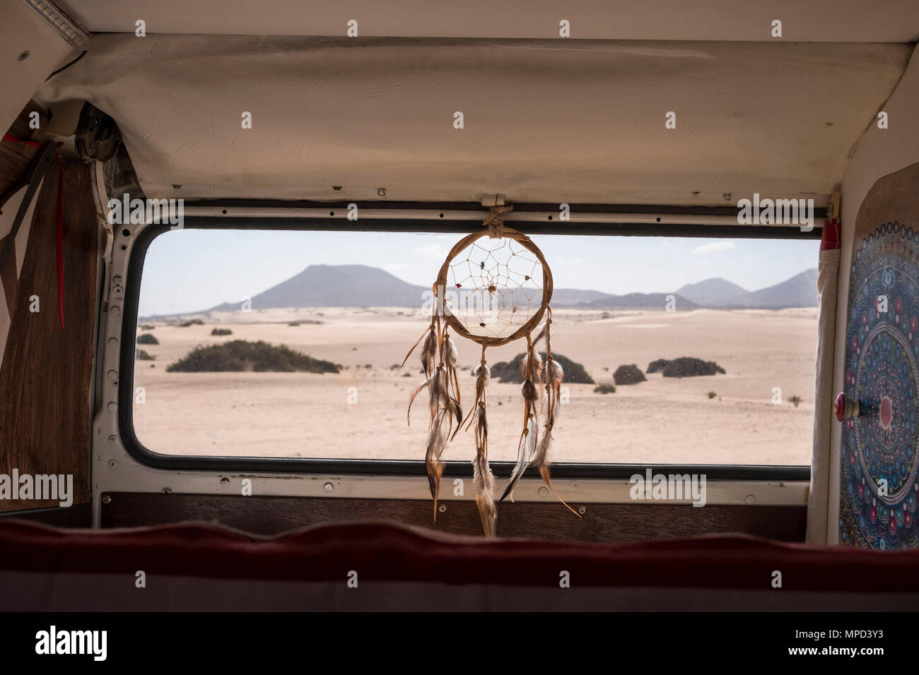 Concetto vanlife per diverse alternative di vita e Wy del viaggio. Dreamcatcher sulla finestra con il deserto e montagne outdoor. mandale a sinistra, qu Foto Stock