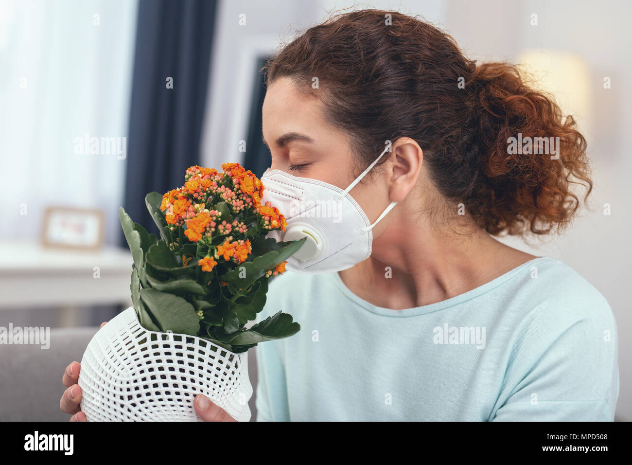 Adolescente lady prova la sua maschera protettiva con il polline dei fiori Foto Stock