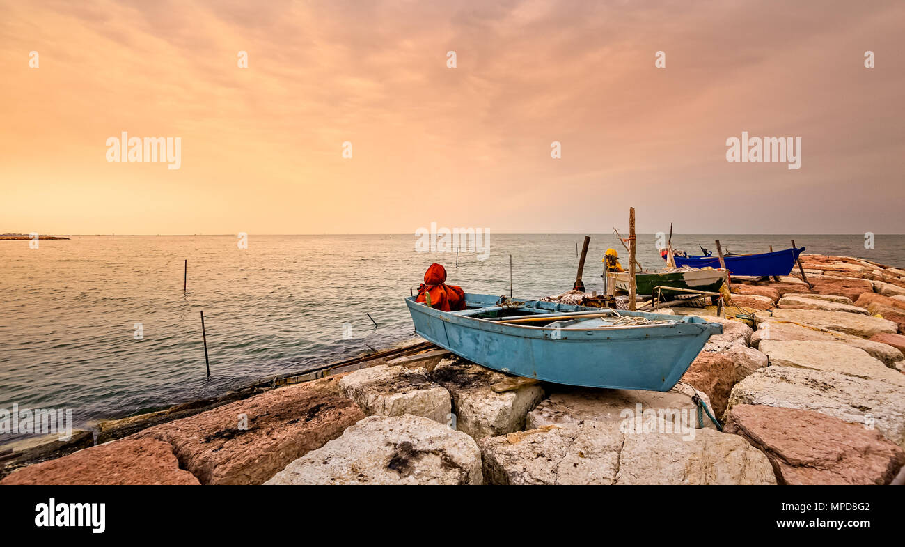 La pesca in barca ormeggiata sulla Scogliera al tramonto. Isola di Pellestrina, Venezia,l'Italia. Foto Stock