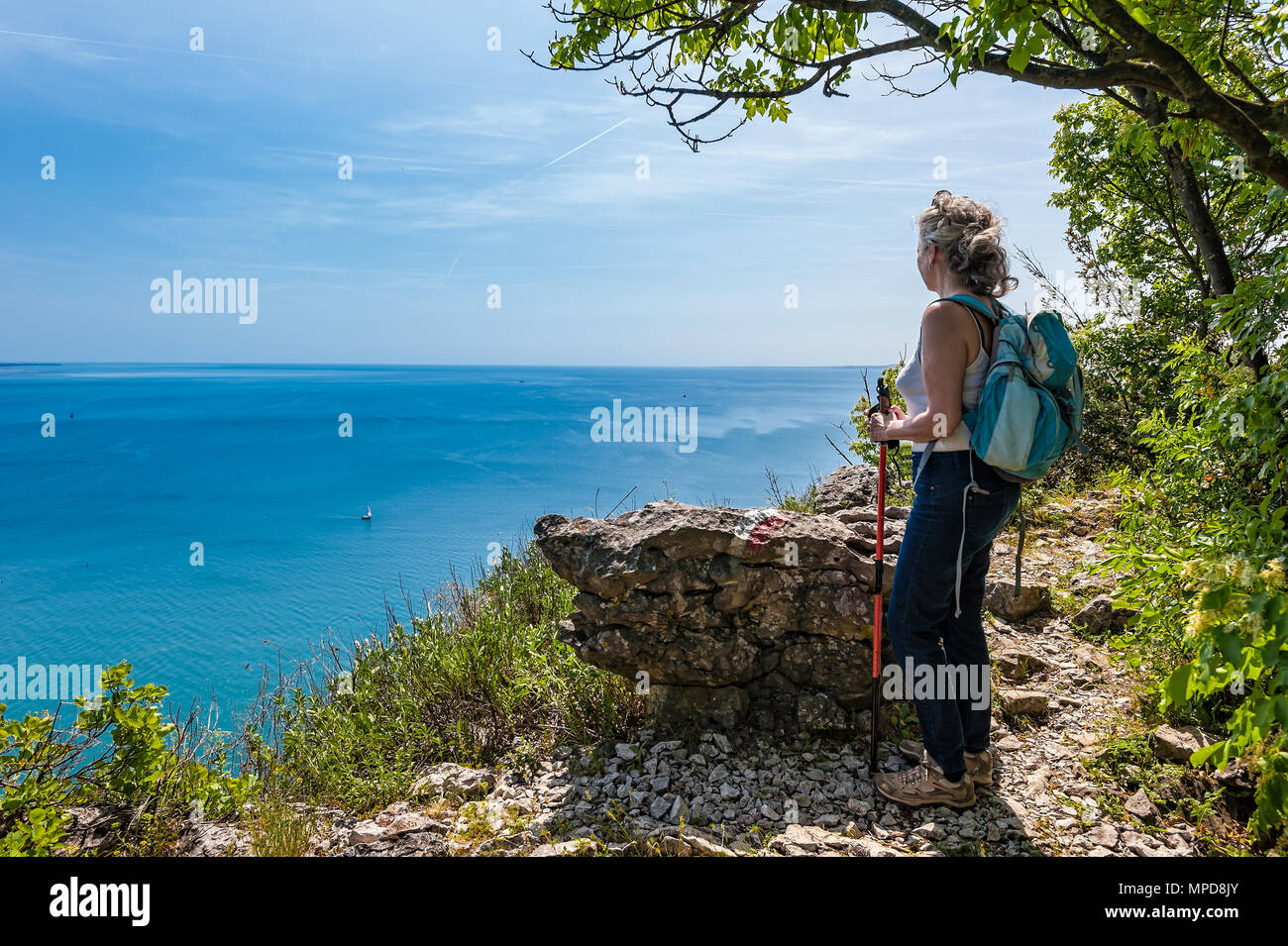 Coppia escursionista femmina con zaino guardando in avanti sul mare, al cielo. Viaggi e stile di vita attivo concept. Trieste,l'Italia. Foto Stock