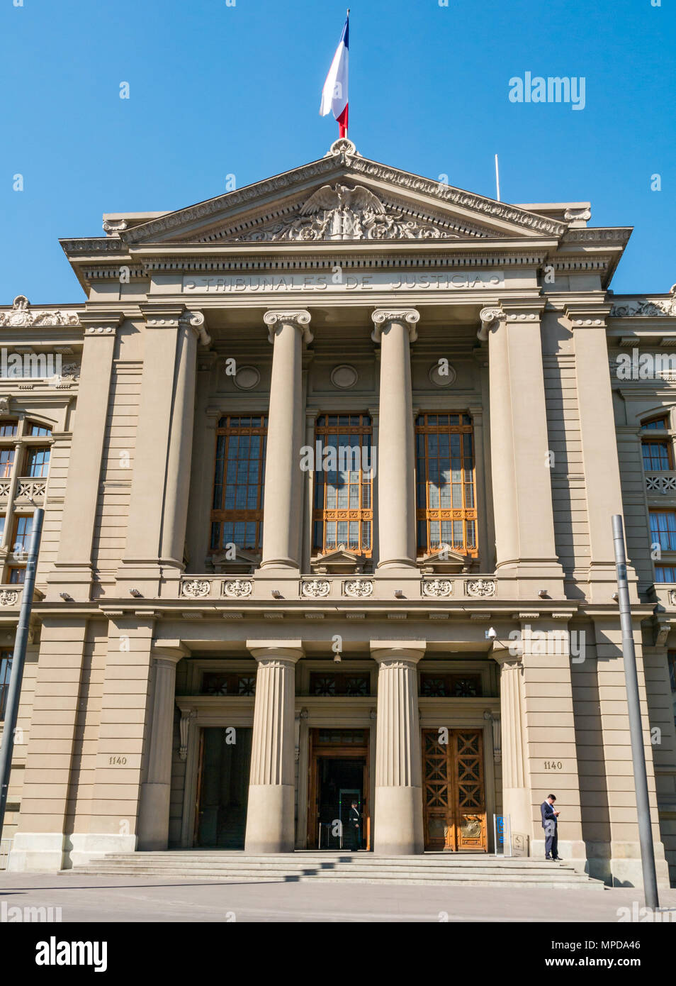 Palazzo dei Tribunali di Giustizia edificio, Santiago del Cile, America del Sud. Uomo che guarda il suo telefono e la protezione. Foto Stock