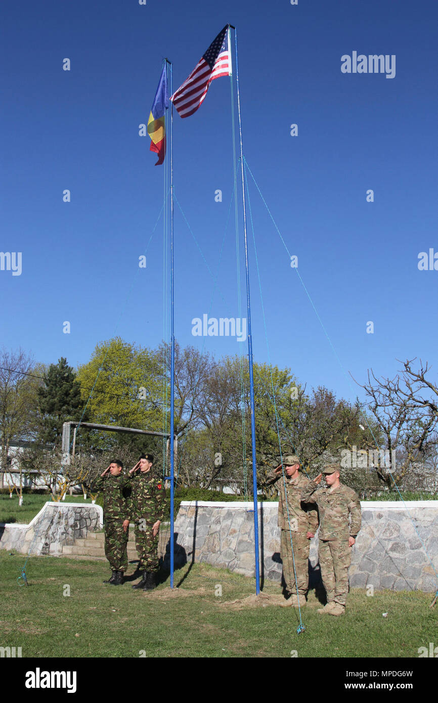 Noi e soldati rumeni alzare i loro rispettivi flag a una cerimonia di apertura a Smardan Area Formazione, Romania il 10 aprile 2017. Entrambi i flag sono state sollevate per mostrare le unità di entrambe le nazioni come di imbarcarsi in un combinato di formazione missionaria per il funzionamento Atlantic risolvere, una missione della NATO che coinvolgono gli Stati Uniti e in Europa per rafforzare la stabilità regionale e di scoraggiare le aggressioni in Europa. ( Foto Stock