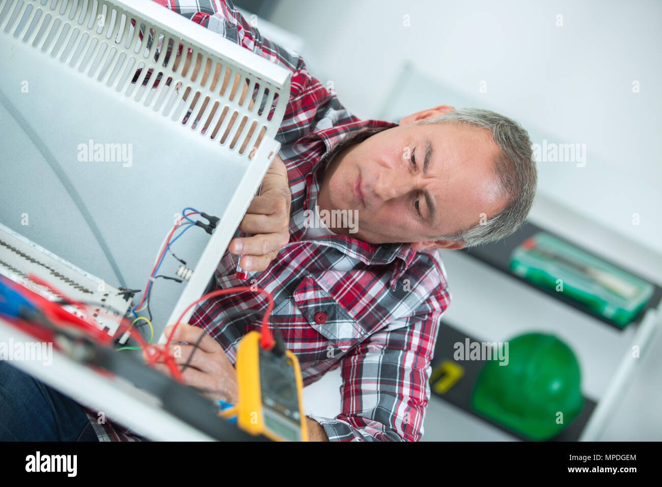 Uomo che utilizza un sistema di misurazione elettronica per il fissaggio del riscaldatore Foto Stock