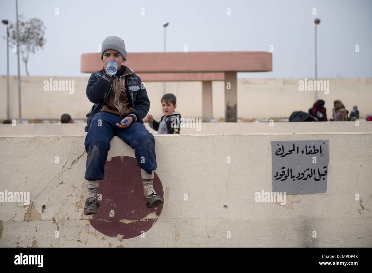 Un internamente sfollati bambino attende in corrispondenza di una stazione di lavorazione in preparazione per essere trasportati in campi per rifugiati nei pressi di Mosul, Iraq, Marzo 03, 2017. (U.S. Foto dell'esercito da Staff Sgt. Alex Manne) Foto Stock