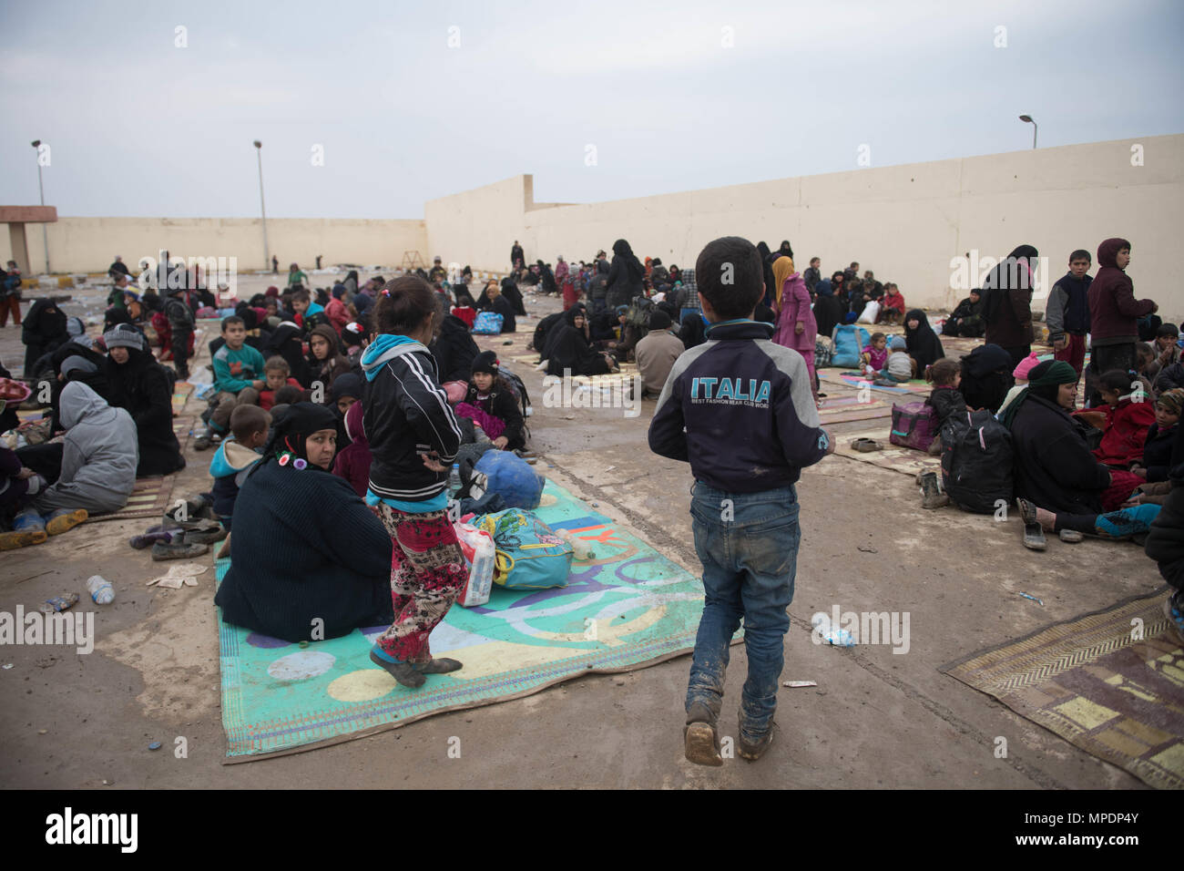 Le donne e i bambini in attesa in una stazione di lavorazione per gli sfollati interni prima di essere trasportati in campi per rifugiati nei pressi di Mosul, Iraq, Marzo 03, 2017. (U.S. Foto dell'esercito da Staff Sgt. Alex Manne) Foto Stock