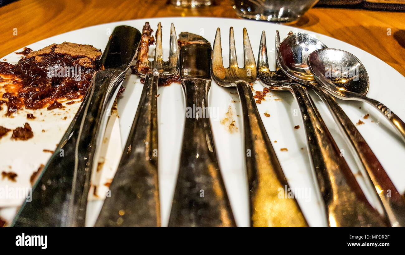 Forcella metallica, un cucchiaio e un coltello con cioccolato finito dessert. finito di concetto di pasto. Foto Stock