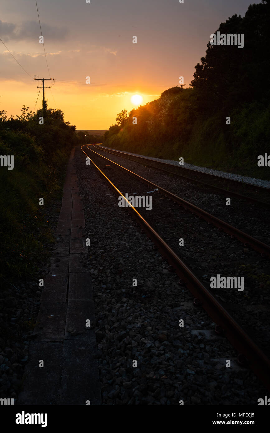 La luce del tramonto riflessa fuori rete guida binari del treno in corrispondenza di Aberthaw, Vale of Glamorgan Foto Stock