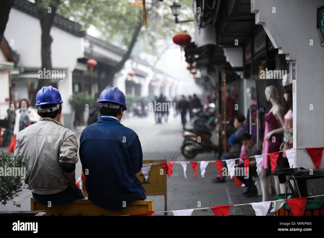 Lavoratori cinesi con casco blu in Hangzhou (Cina). Foto Stock