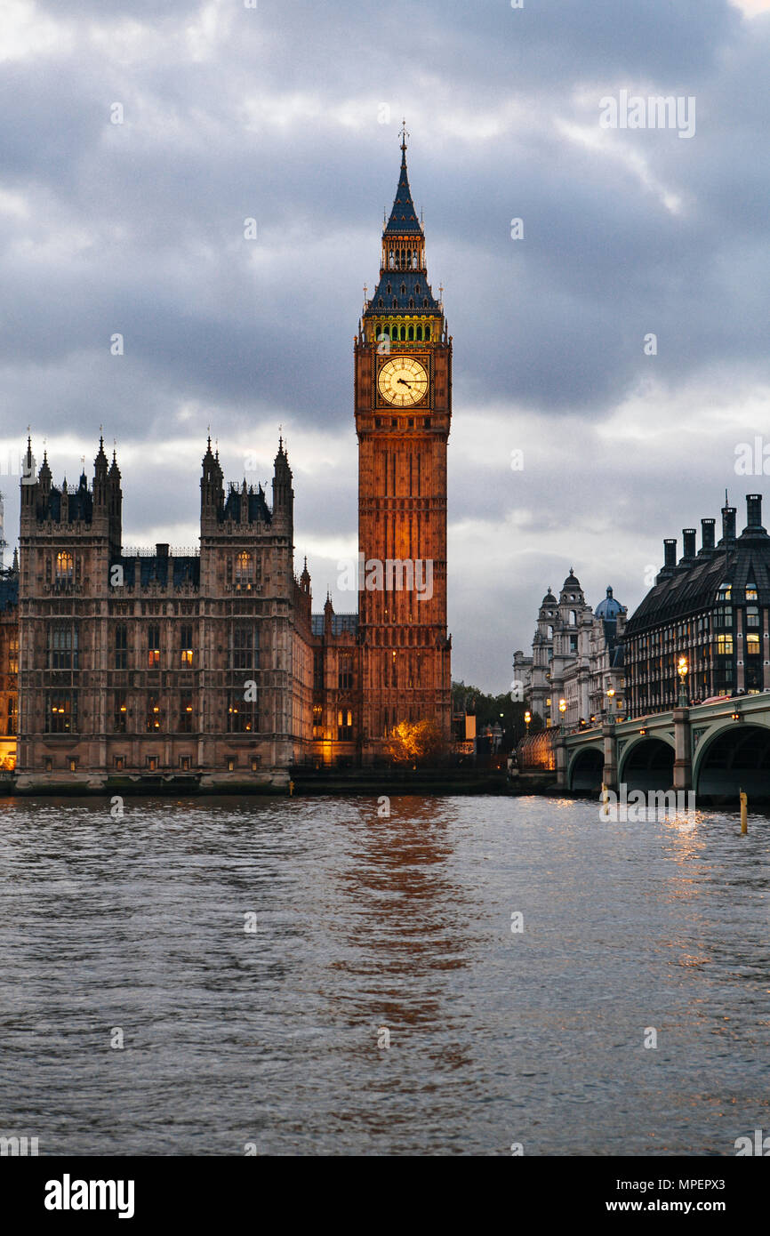 L'immagine verticale di un illuminato il Big Ben e il Parlamento oltre il Tamigi in prima serata Foto Stock