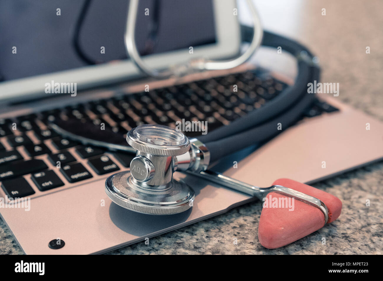 Lo stetoscopio e il martello di riflesso sulla tastiera il ripiano del bancone pronto per l'uso e l'immissione dei dati da personale medico Foto Stock