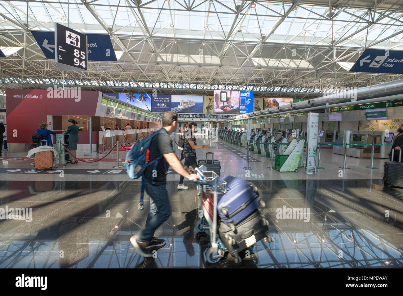 Aeroporto di Roma Fiumicino, scena in interni i passeggeri a piedi con i  bagagli in area di Alitalia Foto stock - Alamy