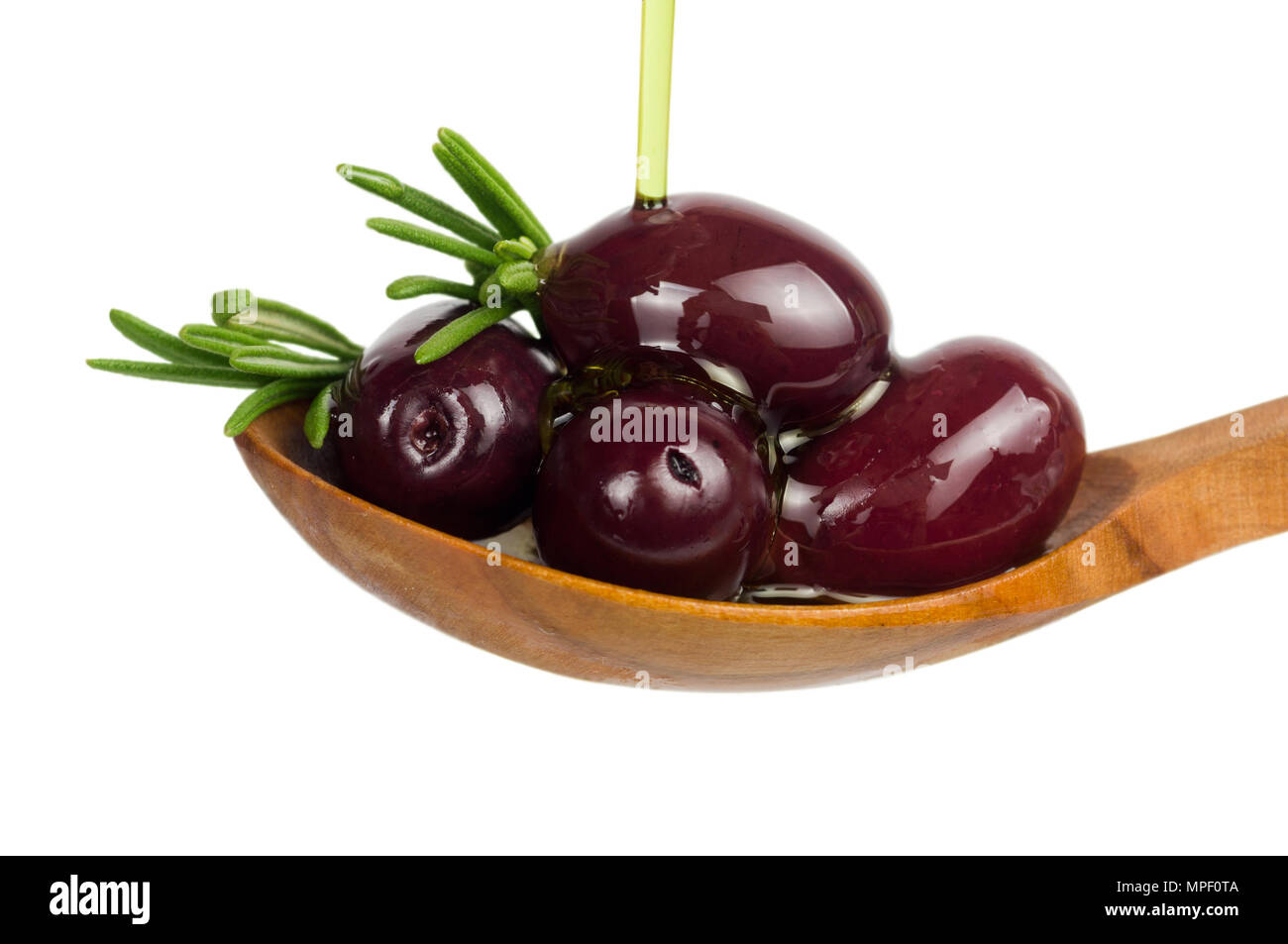 Rosso delle olive in olio al rosmarino su cucchiaio. Versare olio sul cucchiaio isolato su bianco. Foto Stock