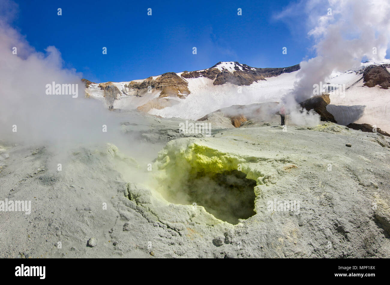 Cratere fumante del vulcano attivo coperte da neve Foto Stock
