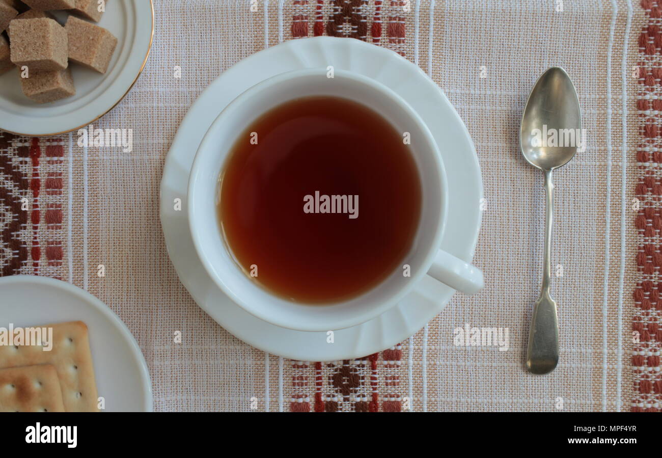 Tazza di tè con su una bella tovaglia vista superiore Foto Stock