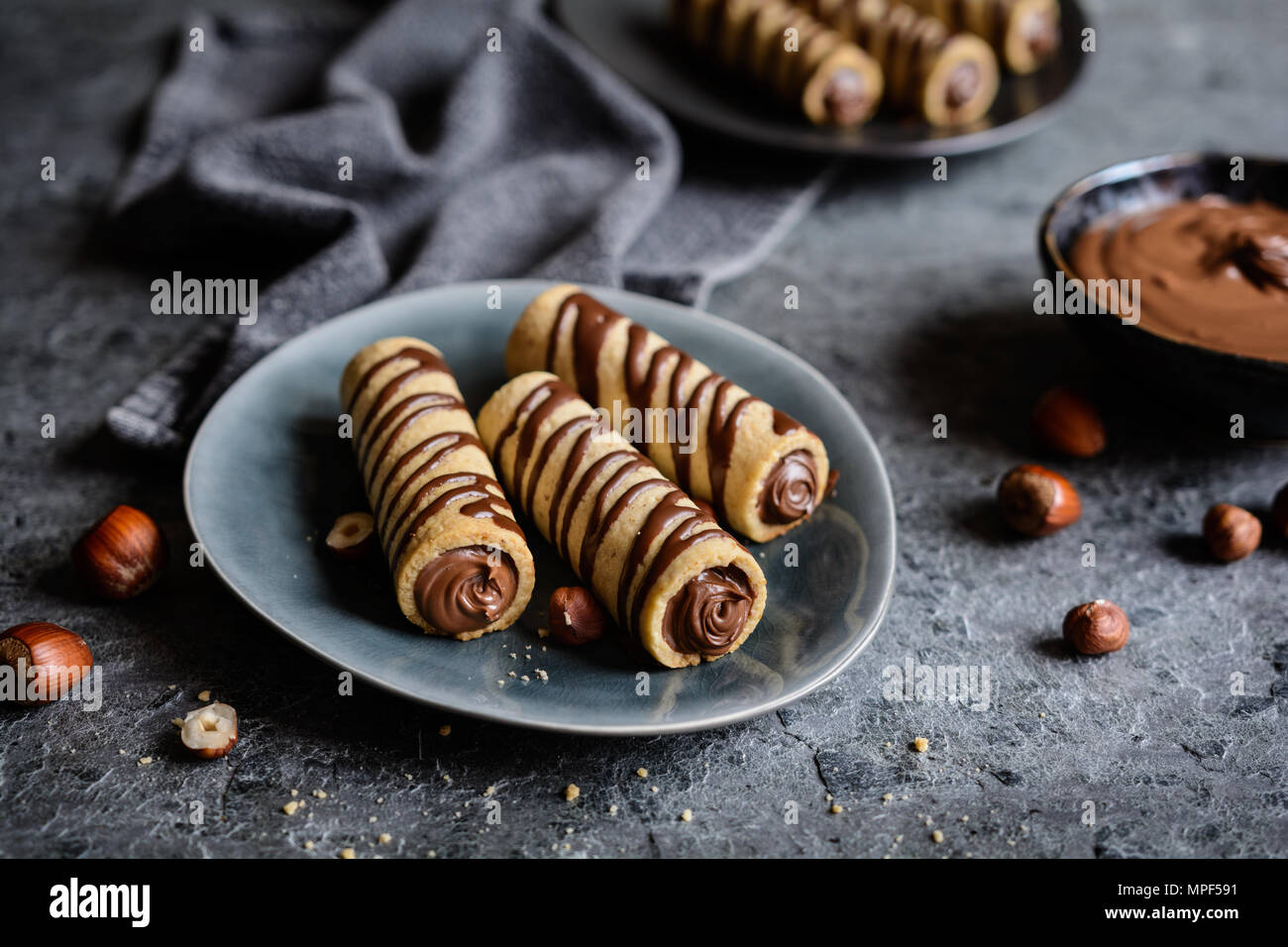 Deliziosi biscotti tubi riempiti con crema di nocciole e cioccolato topping Foto Stock