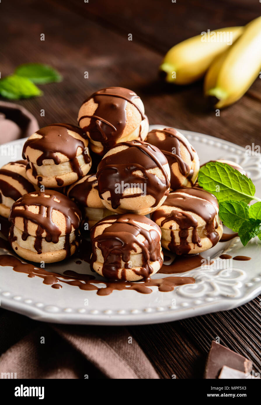 Spugna rotonda biscotti farciti con fettine di banana e guarnita con il cioccolato Foto Stock