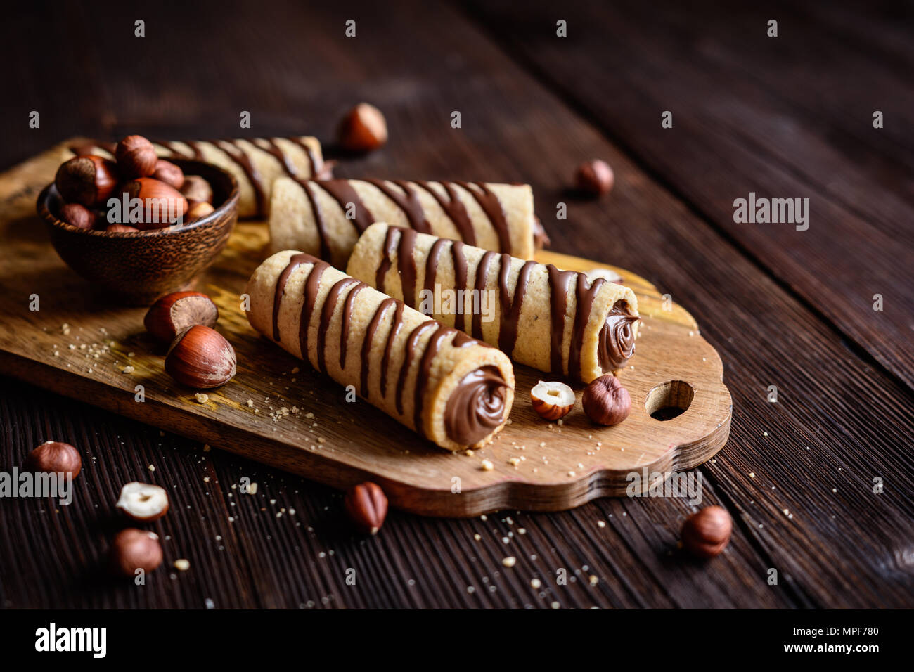 Deliziosi biscotti tubi riempiti con crema di nocciole e cioccolato topping Foto Stock