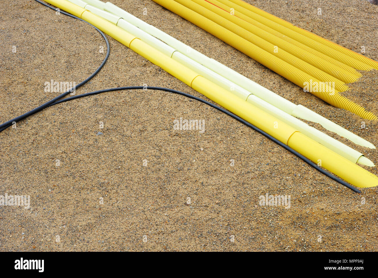 I cavi e i tubi in materiale plastico in sabbia. Foto Stock