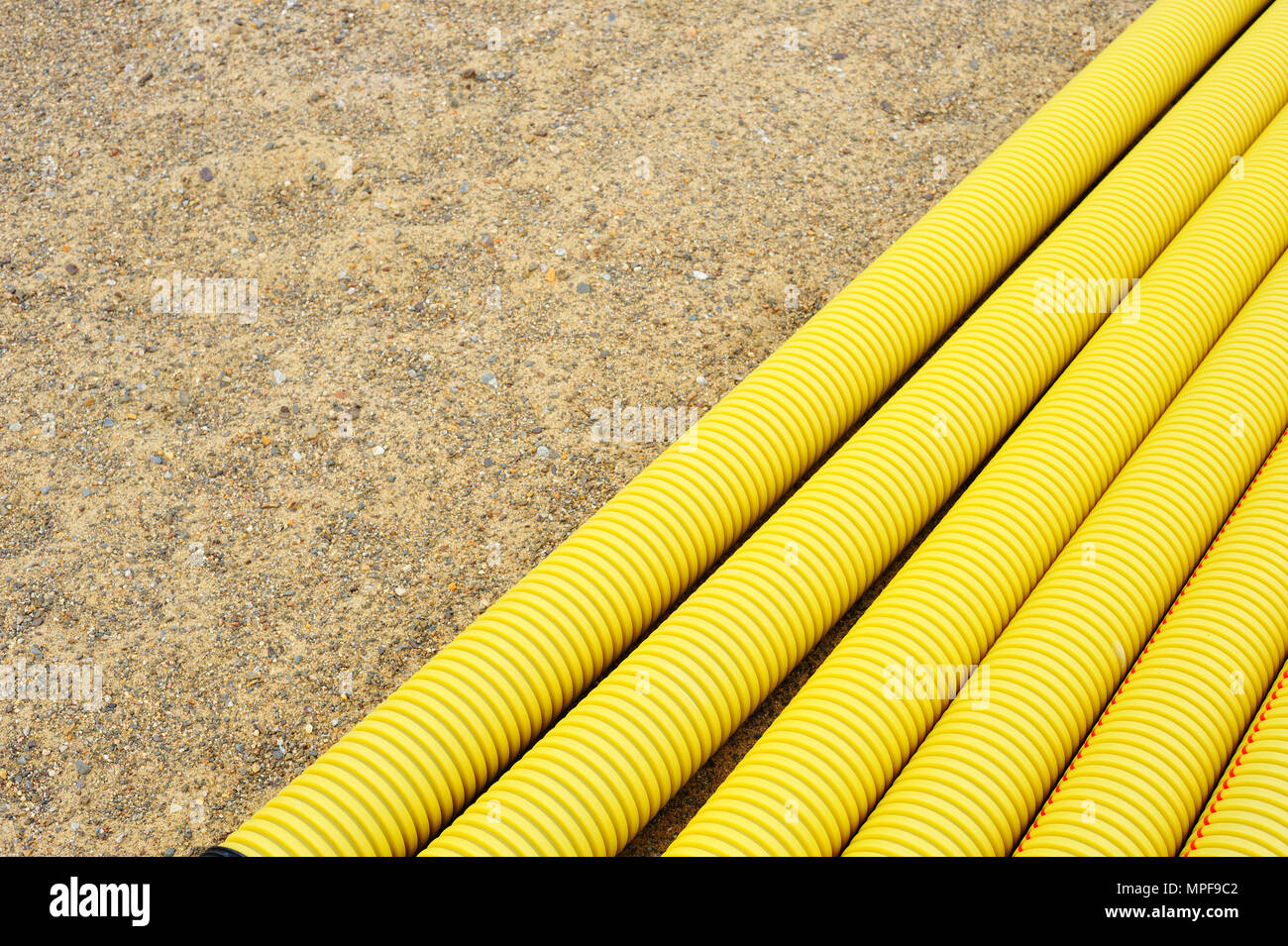 Il giallo di tubi in materiale plastico in sabbia. Foto Stock