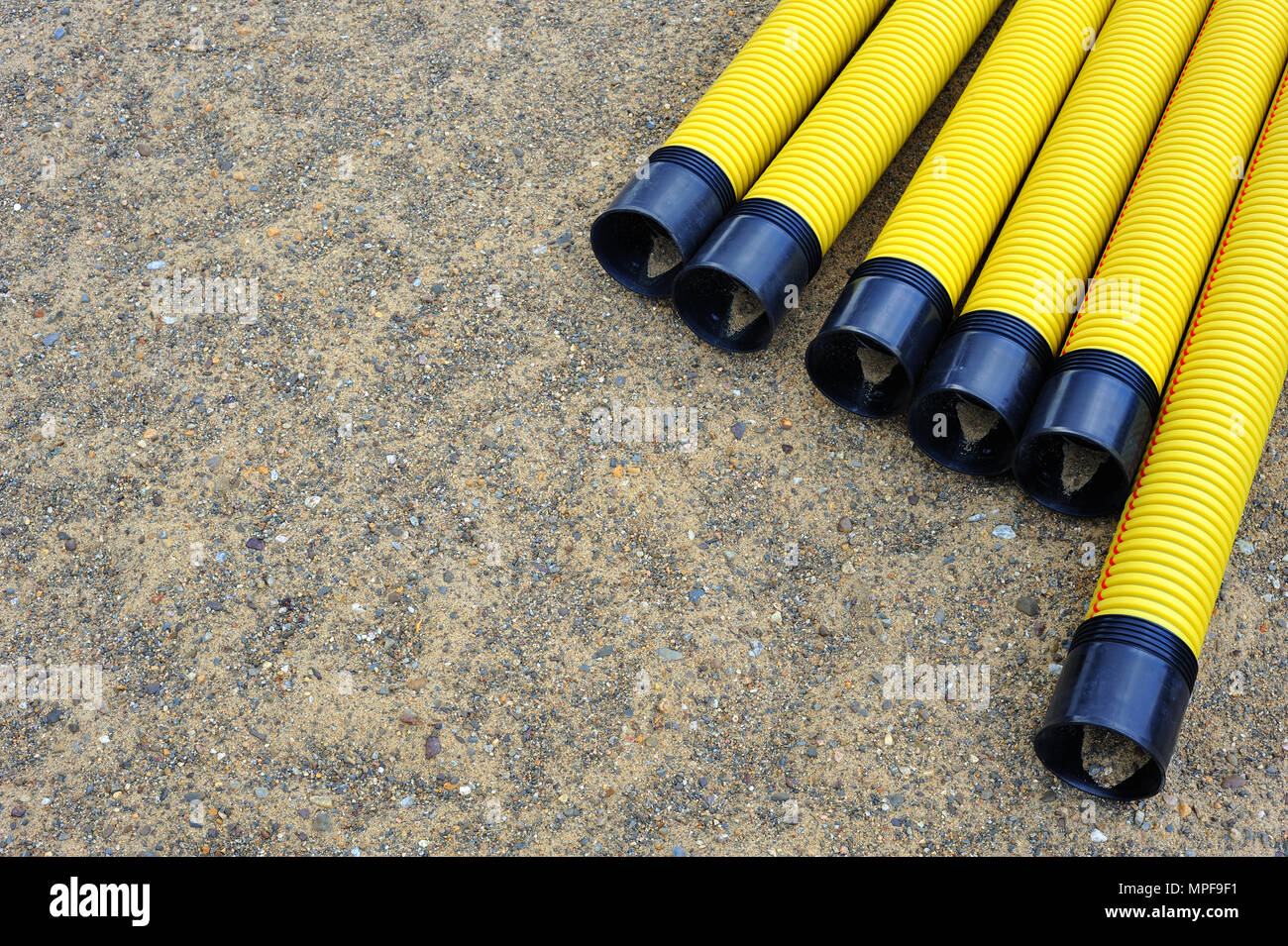 Il giallo di tubi in materiale plastico in sabbia. Foto Stock