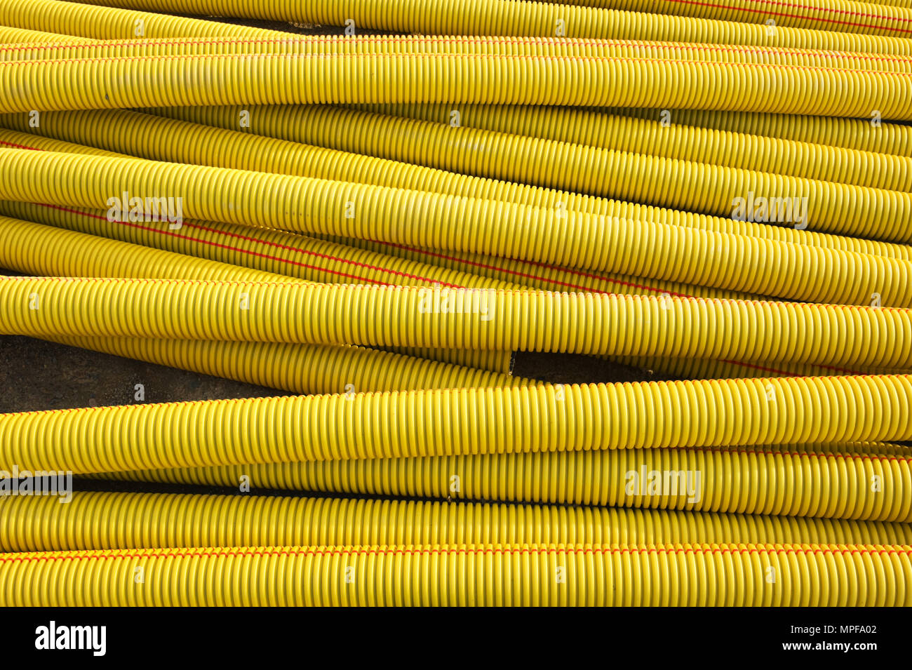 Pila di giallo di tubi in materiale plastico. Foto Stock