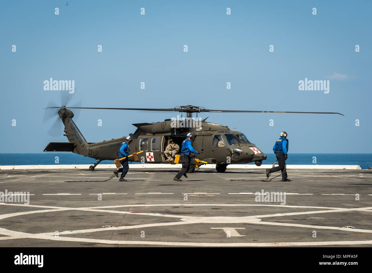 U.S Navy marinai guarnitura e catena di U.S. Esercito UH-60 Blackhawk elicottero dopo l'atterraggio sul trasporto anfibio dock nave USS Green Bay (LPD-20) durante l'esercizio Cobra Gold al largo della costa della Thailandia, Feb 21, 2017. Cobra Gold è il più grande teatro di cooperazione nel campo della sicurezza in esercizio il Indo-Asia-regione del Pacifico ed è parte integrante dell'impegno degli Stati Uniti per rafforzare l'impegno nella regione. (U.S. Foto di Marina di Massa lo specialista di comunicazione 2a classe Ciad M. Butler) Foto Stock