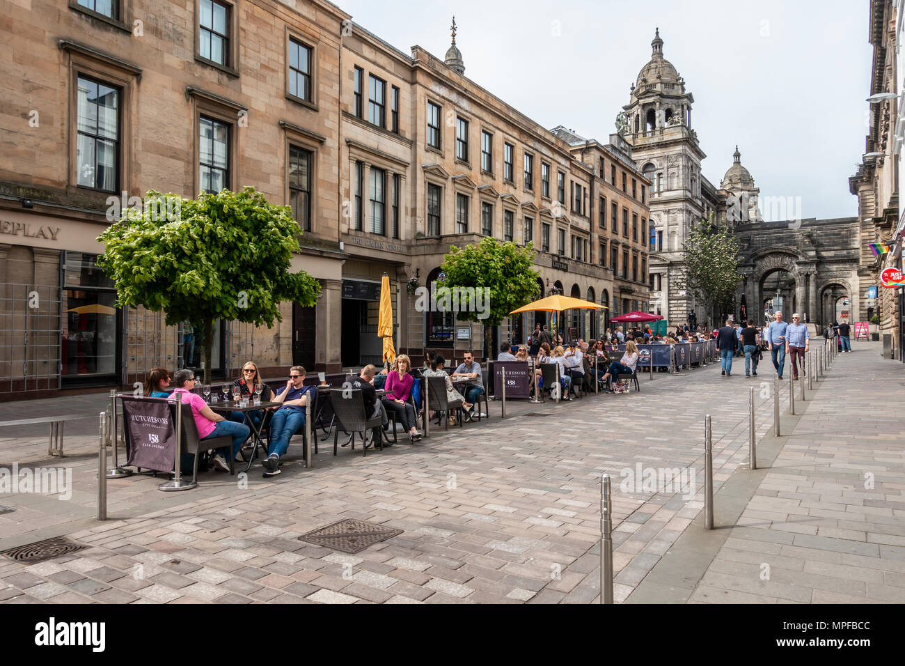 John Street nel quartiere di Merchant City di Glasgow, in una calda serata di maggio, con gente che cammina e altri a mangiare e a bere. La Scozia, Regno Unito Foto Stock