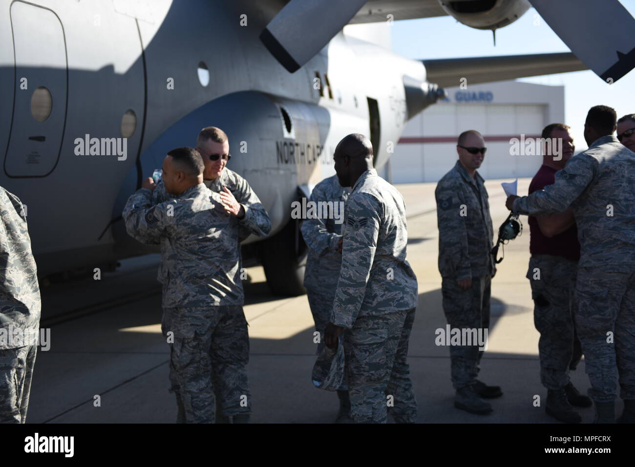 Il brigadiere generale Roger E. Williams abbracci e dice addio a una distribuzione di N.C. Air National Guardsman chi è in partenza per supportare il funzionamento libertà di sentinella, mentre sul flightlint del North Carolina Air National Guard Base, l'Aeroporto Internazionale Charlotte Douglas, Feb 24, 2017. È la distribuzione finale utilizzando il C-130 aereo modello prima che l'unità delle transizioni al usando C-17's. Foto Stock