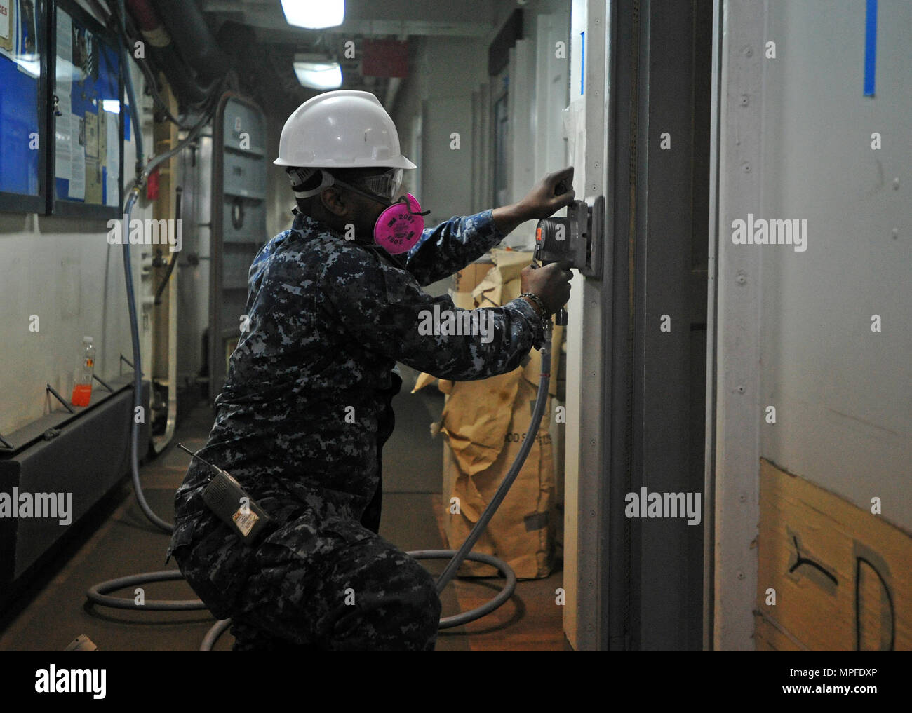 Hospital Corpsman 3rd Class sabbierà un telaio della porta nella sala d'attesa medica a bordo della USS Blue Ridge (LCC 19) a Yokosuka, Giappone, 22 febbraio 2017. La nave ammiraglia sta attraversando un lungo periodo di manutenzione per modernizzare i sistemi e mantenere la capacità operativa come solida piattaforma di comunicazione nell'area operativa della 7a flotta statunitense. Foto Stock