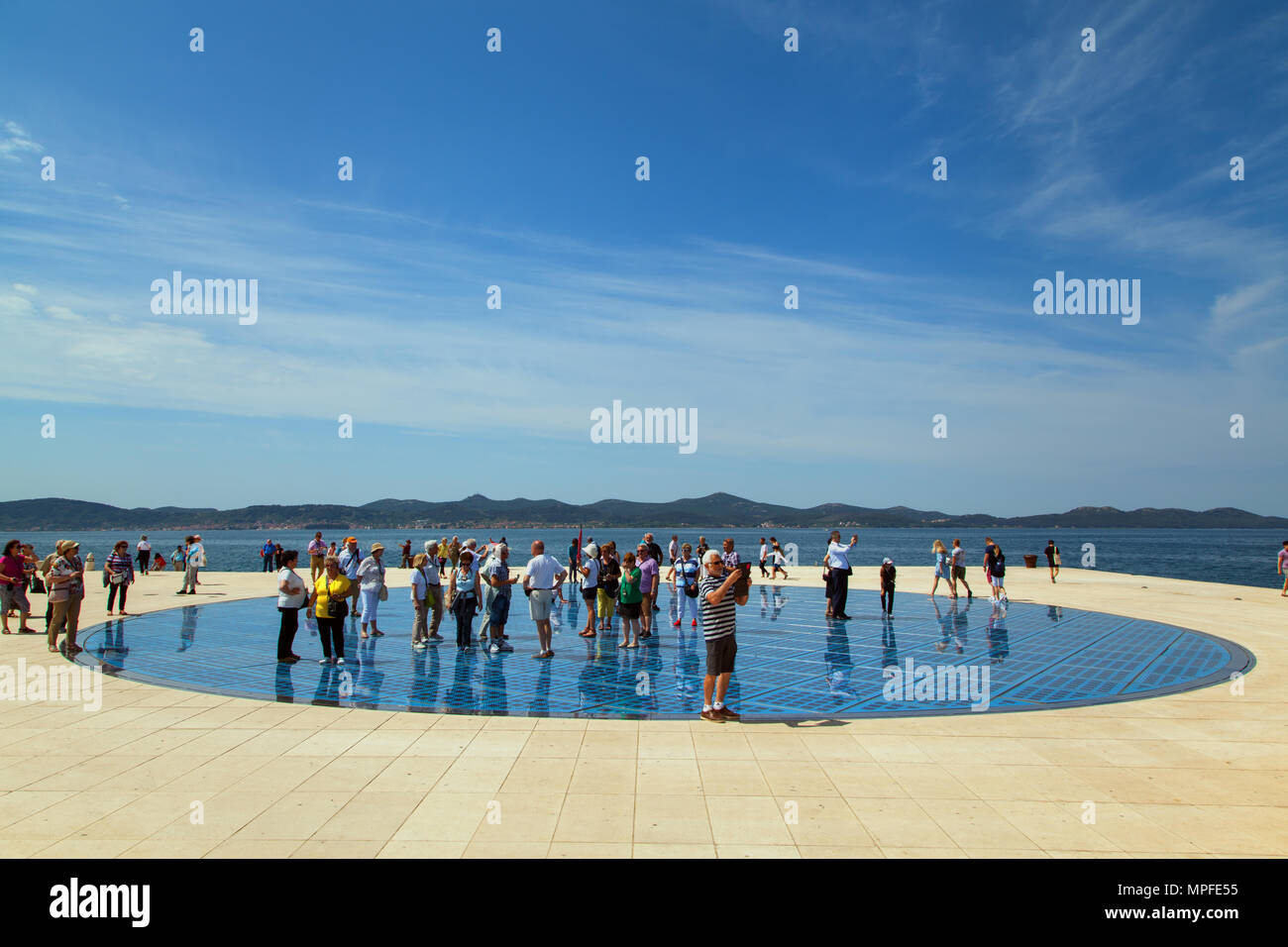 Villeggianti e turisti in piedi sul photovolt installazione, il monumento al sole nel porto di Zadar croazia Foto Stock