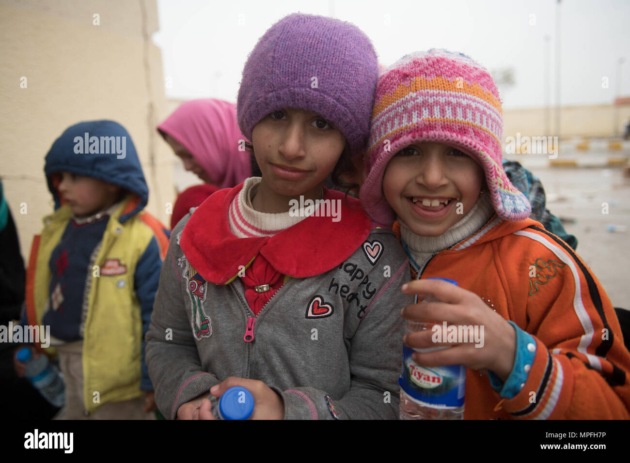 I bambini sfollati resto in corrispondenza di una stazione di lavorazione in preparazione per essere trasportati in campi per rifugiati nei pressi di Mosul, Iraq, Marzo 2, 2017. (U.S. Foto dell'esercito da Staff Sgt. Alex Manne) Foto Stock