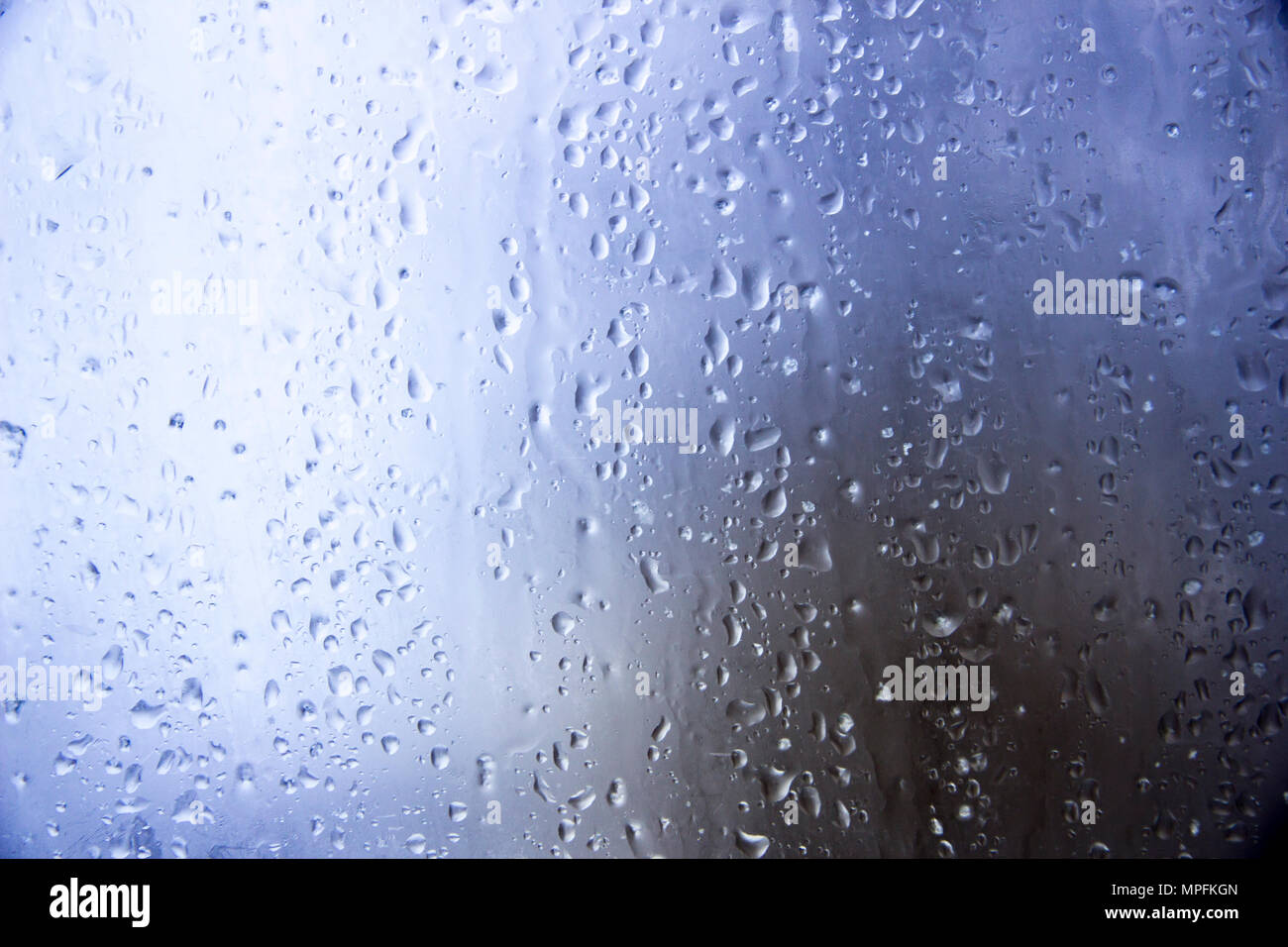 Gocce di acqua sul vetro nei riflessi del sole Foto Stock