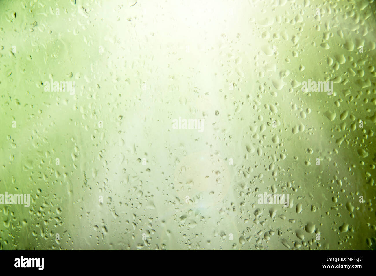 Gocce di acqua sul vetro nei riflessi del sole Foto Stock