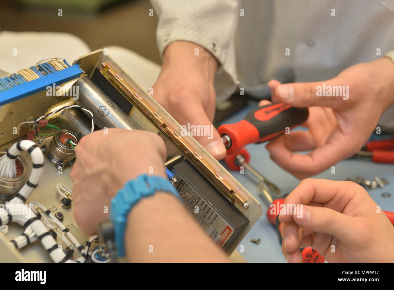 Tecnici della manutenzione 791st Squadron laboratorio di elettronica  rimuovere le viti da un controller monitor a Minot Air Force Base, N.D.,  Marzo 2, 2017. Laboratorio di Elettronica tecnici ispezionare, risoluzione  dei problemi