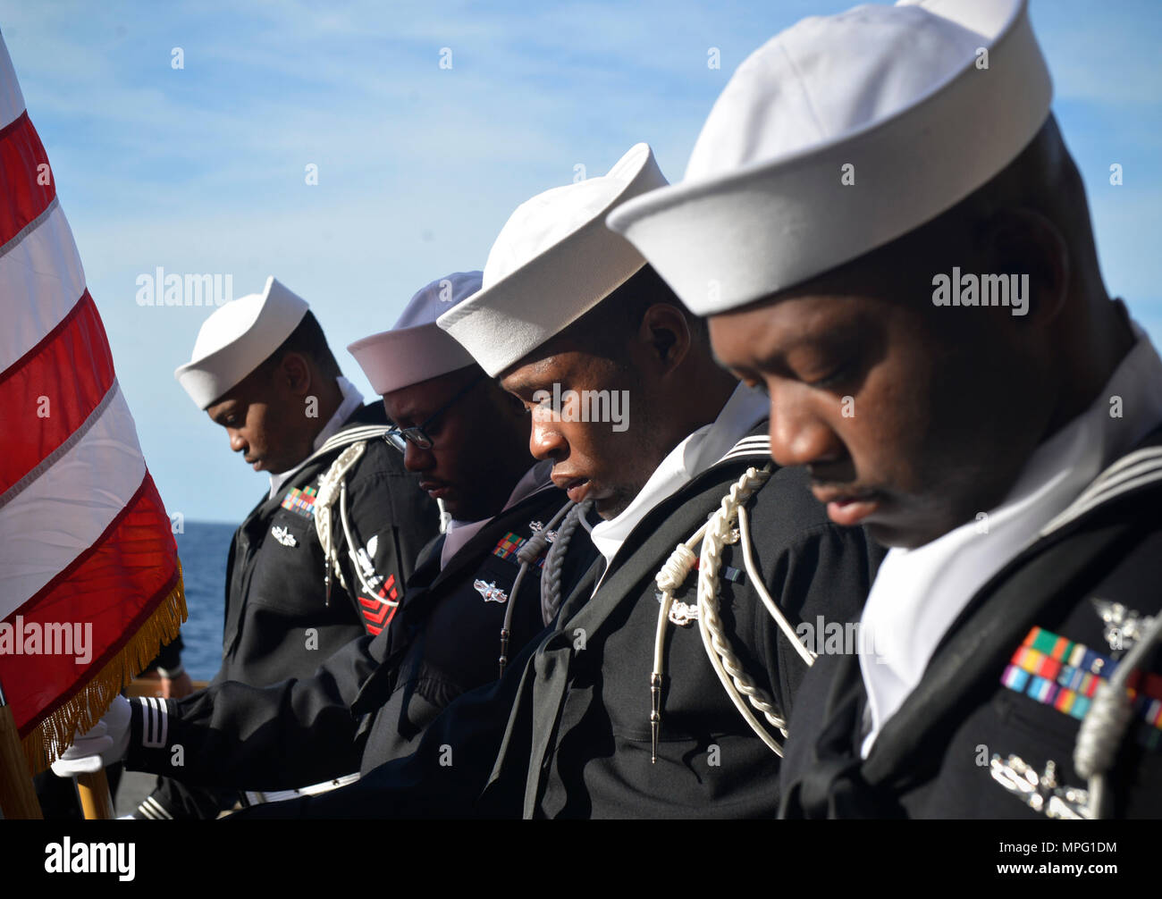 170311-N-RL456-0059 OCEANO ATLANTICO (11 marzo 2017) marinai bow le loro teste in preghiera durante la sepoltura in mare cerimonia a bordo dell'assalto anfibio nave USS Iwo Jima (LHD 7). La nave è in corso conducendo in una serie di qualifiche e certificazioni come parte della fase di base della formazione in preparazione per le operazioni future e delle installazioni. (U.S. Foto di Marina di Massa lo specialista di comunicazione 2a classe Hunter S. Harwell/rilasciato) Foto Stock