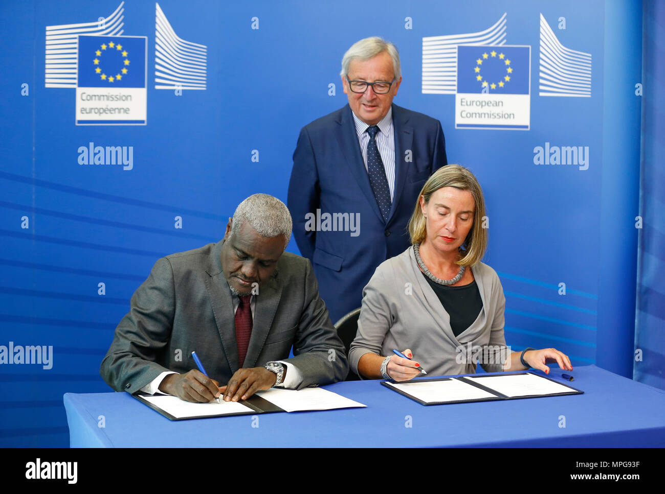 Bruxelles, Belgio. 23 Maggio, 2018. Commissione dell'Unione africana Presidente Moussa Faki Mahamat (L anteriore) firma un memorandum di cooperazione nel campo della pace, la sicurezza e la governance con l' Alto rappresentante dell' Unione europea per gli Affari Esteri e la politica di sicurezza Federica Mogherini (R) anteriore come Presidente della Commissione Europea Jean Claude Juncker (retro) testimoni la firma dopo la nona riunione della Commissione europea e la Commissione dell'Unione africana a Bruxelles, Belgio, 23 maggio 2018. Credito: Voi Pingfan/Xinhua/Alamy Live News Foto Stock