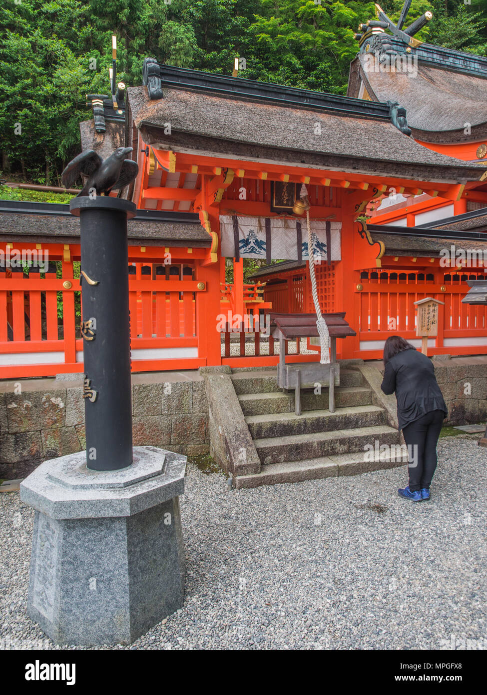 La donna gli archetti in preghiera nel Santuario dedicato a Yatagarasu, il tripiede di crow a Kumano Nachi Taisha, prefettura di Wakayama, Giappone Foto Stock