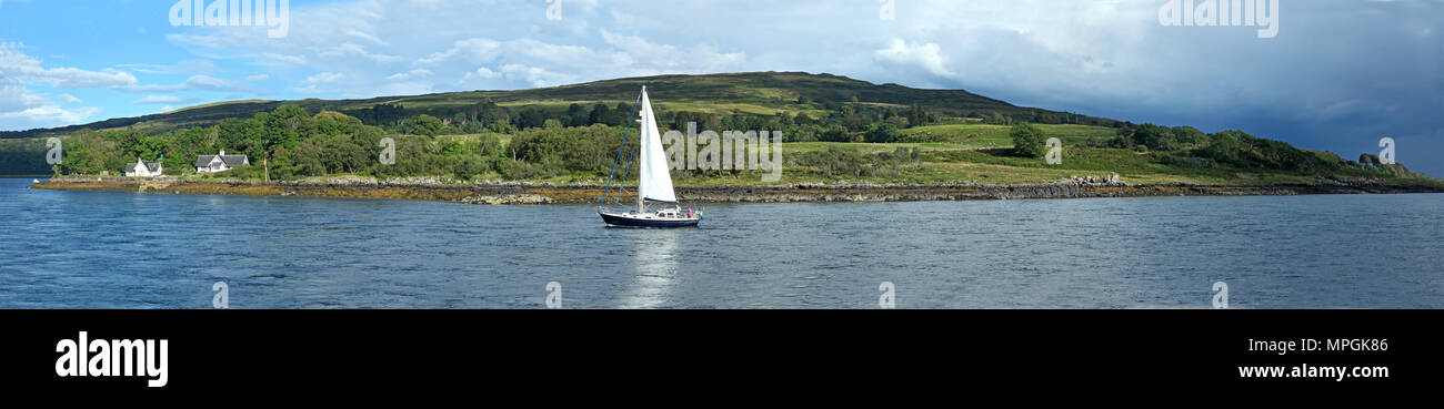 Barca a vela su un lago scozzese, belle colline in background Foto Stock