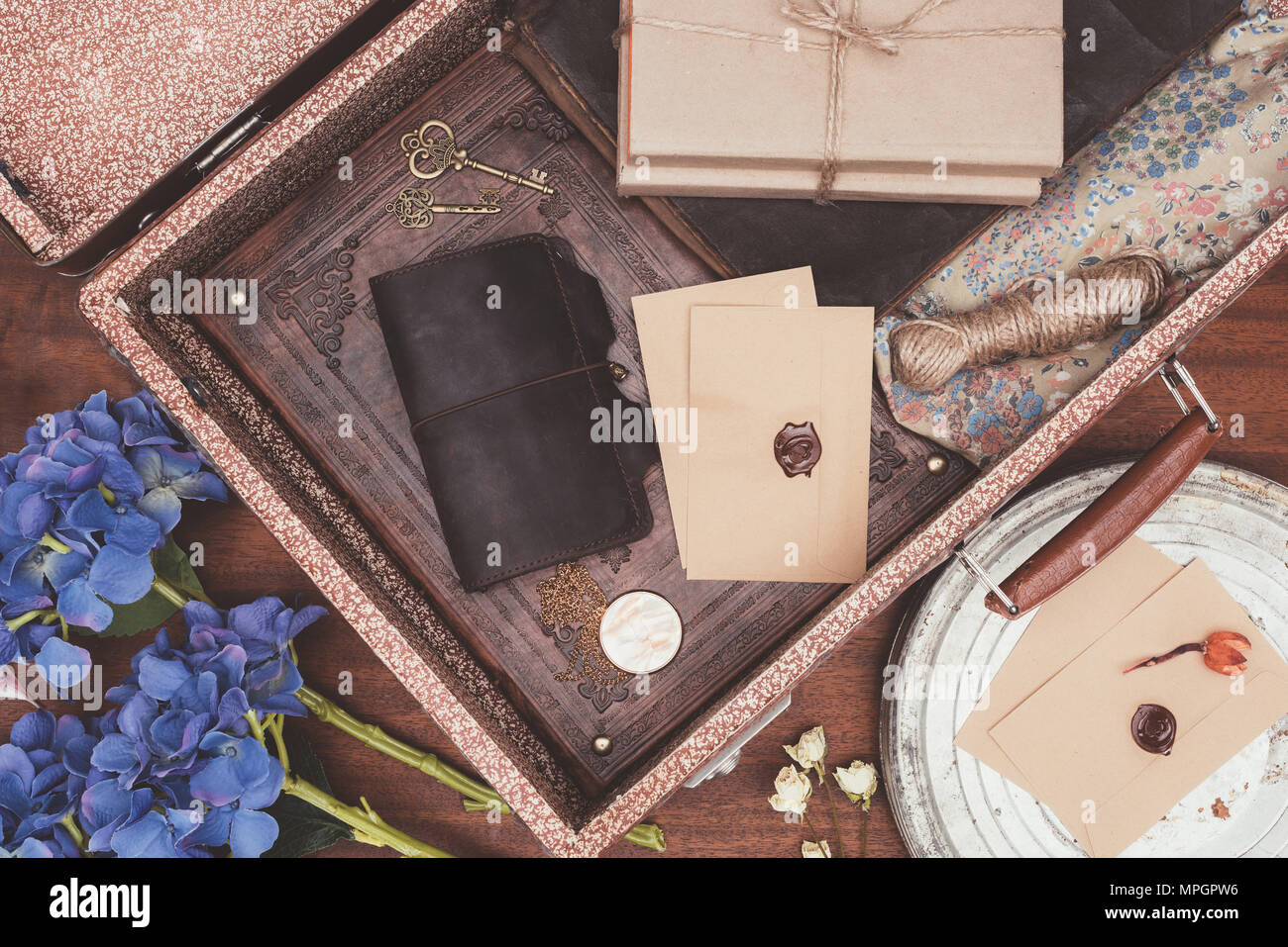 Vista superiore della aperto vintage valigia con oggetti su sfondo di legno Foto Stock