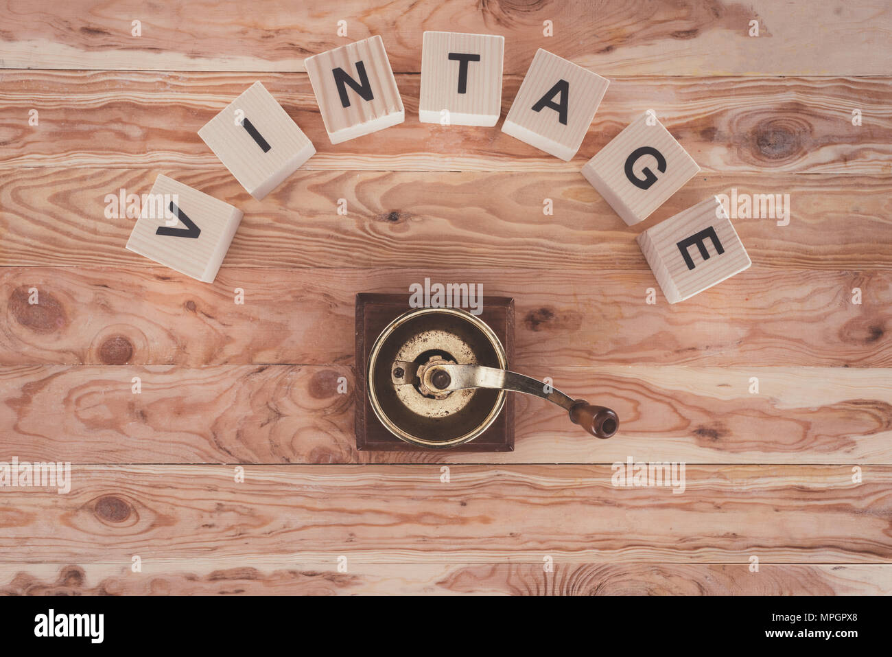 Vista dall'alto di cubi con lettere e macinino da caffè su sfondo di legno Foto Stock